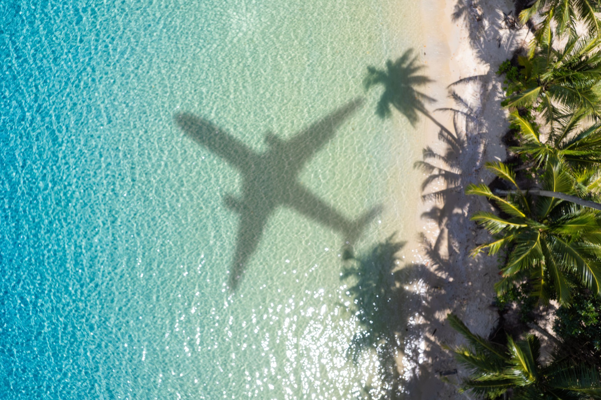 Aerial view of passenger plane silhouette and sandy beach blue sea with waves at sunset Summer vacation sea travel concept